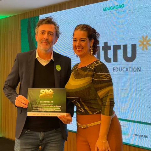 Nei Tessari Filho, gestor da Rede Enem, representou a Vitru durante o evento e recebeu a premiação das mãos de Greice Giovannoni, líder de Eventos e Comercial do Grupo Amanhã